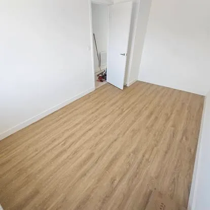 Light oak-effect plank floor fitted in a bedroom