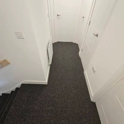 Flecked grey carpet fitted along a landing
