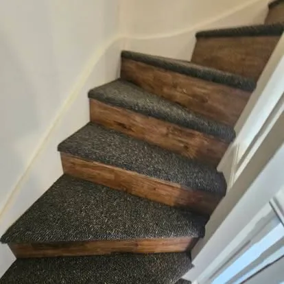 Carpet treads and wood-effect risers on a turning staircase